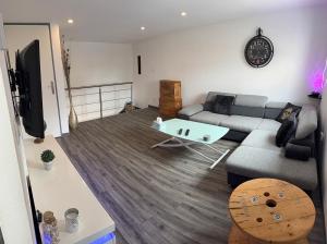 a living room with a couch and a table at Elegant duplex au 3 frontières in Kingersheim