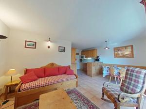 a living room with a couch and a kitchen at Appt 3 pièces, 6 couchages, proche commerces et pistes, parking inclus, animaux admis - FR-1-241-177 in Le Grand-Bornand
