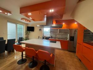 a kitchen with orange cabinets and a kitchen island with orange chairs at Sabina house in Vestec