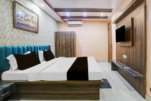 a bedroom with a bed and a flat screen tv at Hotel O Rameshwar Inn in Prayagraj