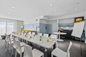 a conference room with a long table and white chairs at Hotel Erwin Venice Beach in Los Angeles