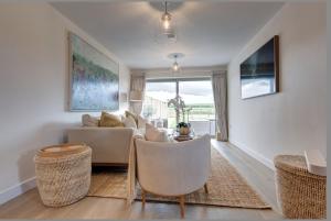 a living room with a couch and chairs at No 1 The Hides Luxury House in North Norfolk in Titchwell