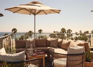a patio with a couch and an umbrella at Hotel Erwin Venice Beach in Los Angeles