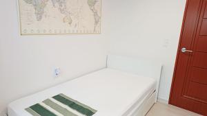 a bed in a room with a map on the wall at 무료주차 수원역차량 5분 행궁동차량7분 in Suwŏn-yŏk