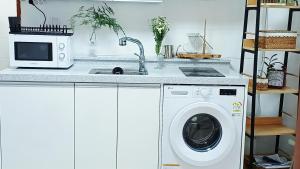 a kitchen with a washing machine and a microwave at 무료주차 수원역차량 5분 행궁동차량7분 in Suwŏn-yŏk