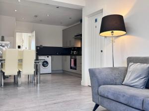 a living room and kitchen with a couch and a table at OX London Heathrow stay - 1 BUS to HEATHROW in New Bedfont