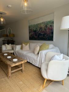 a living room with a white couch and a table at No 1 The Hides Luxury House in North Norfolk in Titchwell