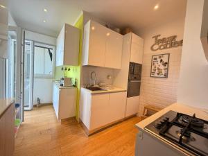 a kitchen with white cabinets and a stove at Terrazza sul mare in Ladispoli