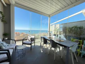 a dining room with a table and chairs and a large window at Terrazza sul mare in Ladispoli