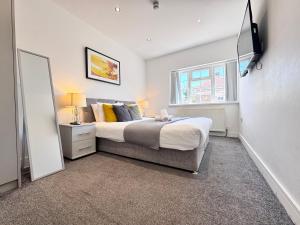 New BedfontにあるOX London Heathrow stay - 1 BUS to HEATHROWのベッドとテレビのある寝室