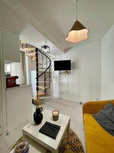 a living room with a spiral staircase and a table at T1 Duplex Cosy - Madeleine - Netflix in Bergerac