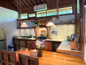 a kitchen with a wooden table with flowers on it at Villa Helios in Pai