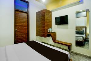 Un dormitorio con una cama y un televisor. en Hotel O JAIPUR ONE, en Jaipur 23 fotos más