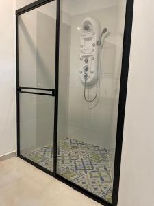 Una ducha con un teléfono en una vitrina en TURULEKA Hostel, en Roldanillo