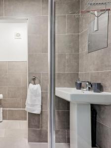 a bathroom with a sink and a shower at Large House Erith DA8 - 6 BDR - Sleeps up to 12 Guest - Parking - Garden - WiFi- Contractors - Families - Groups - Discounts Available for Long Term Bookings! in Erith