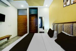 Un dormitorio con una gran cama blanca en una habitación. en Hotel O JAIPUR ONE, en Jaipur