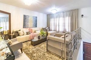 a living room with a couch and a bed in a room at CASA CONFORTÁVEL, 5 SUITES e 1 QUARTO in Belém