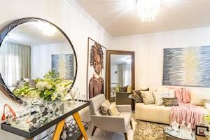 a living room with a couch and a mirror at CASA CONFORTÁVEL, 5 SUITES e 1 QUARTO in Belém