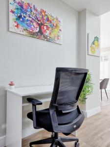 une chaise de bureau noire assise devant un bureau dans l'établissement Large House Erith DA8 - 6 BDR - Sleeps up to 12 Guest - Parking - Garden - WiFi- Contractors - Families - Groups - Discounts Available for Long Term Bookings!, à Erith