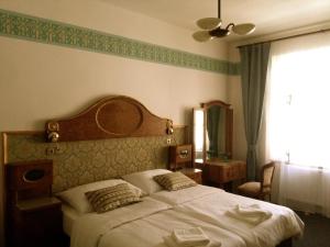une chambre avec un grand lit et une fenêtre dans l'établissement Hotel Kapitán, à Žatec