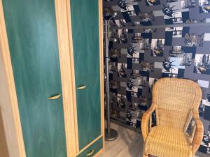 una sedia e una porta in una stanza con un muro di Chambre d hôte proche Le Mans a Sargé-lès-Le Mans