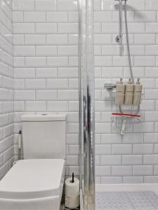 La salle de bains est pourvue de toilettes et de carreaux de métro blancs. dans l'établissement Large House Erith DA8 - 6 BDR - Sleeps up to 12 Guest - Parking - Garden - WiFi- Contractors - Families - Groups - Discounts Available for Long Term Bookings!, à Erith