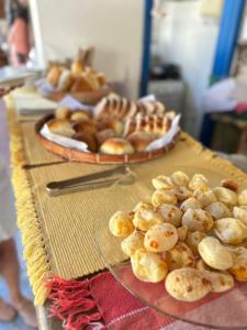 a table with two plates of breads and pastries at Pousada Casa das Rosas in Búzios