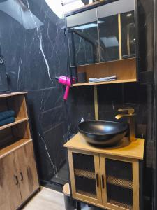 bagno con lavandino e parete nera di Le boudoir des jouissances perverses a Chasse-sur-Rhône