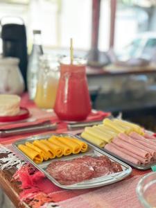 a table topped with meats and cheese and other foods at Pousada Casa das Rosas in Búzios