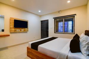 a bedroom with a bed and a flat screen tv at Hotel O MOODY MOON.02 in Bālianta