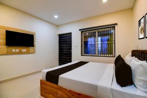 a bedroom with a bed and a flat screen tv at Hotel O MOODY MOON.02 in Bālianta