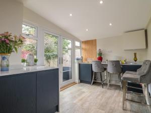 a kitchen with a counter and some chairs in it at Alexandra Retreat in Skegby