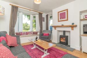 a living room with a couch and a fireplace at Artro in Llanbedr