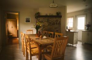 une salle à manger avec une table et des chaises en bois dans l'établissement Longford Holiday Red Rose Self Catering Cottage, à Longford