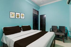 a bedroom with a large bed with blue walls at Hotel O Shivam International in Utrāhtia