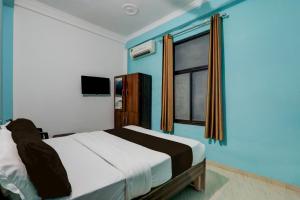 a bedroom with a large bed and a window at Hotel O Shivam International in Utrāhtia