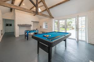 two pool tables in a room with a fireplace at Hendre-Feinws in Pwllheli