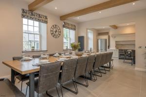 a large dining room with a long table and chairs at Hendre-Feinws in Pwllheli