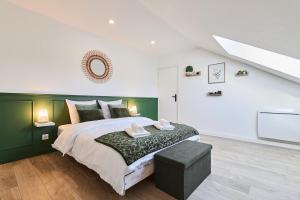une chambre avec un grand lit avec une tête de lit verte dans l'établissement Le Cliquot - Maison - Spa - Jardin - Parking Gratuit, à Reims