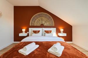 une chambre avec un grand lit avec deux serviettes dessus dans l'établissement Le Cliquot - Maison - Spa - Jardin - Parking Gratuit, à Reims