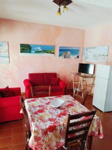 ein Wohnzimmer mit einem Tisch und einer roten Couch in der Unterkunft Casa Vacanze Tropea in Santa Domenica