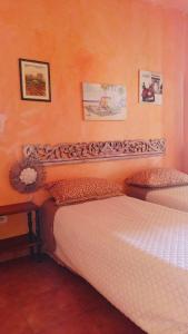 2 Einzelbetten in einem Zimmer mit orangefarbenen Wänden in der Unterkunft Casa Vacanze Tropea in Santa Domenica