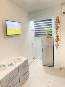 a kitchen with a refrigerator and a tv on the wall at Suite Terraza Verde Inoa in Inoa