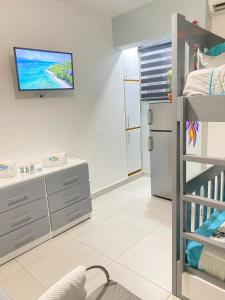 - une chambre avec des lits superposés et une télévision murale dans l'établissement Suite Terraza Verde Inoa, à Inoa