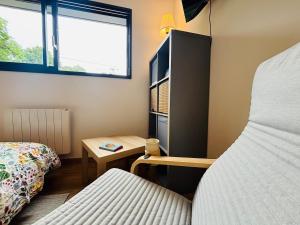a small bedroom with a bed and a table at Echappée Bel' cosy studio Baie de Somme in Bellancourt +8 photos