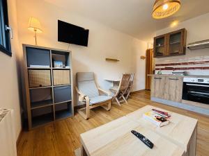 a living room with a table and a kitchen at Echappée Bel' cosy studio Baie de Somme in Bellancourt