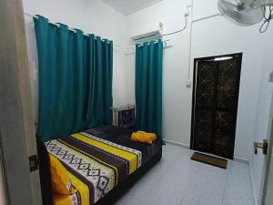 a bedroom with a bed with blue drapes at Homestay Puteri D'Durian Guling in Bukit Payong