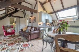 a kitchen and living room with a couch and a table at Lloft-Sarn in Sarn