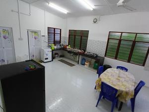 a kitchen with a table and chairs in a room at Homestay Puteri D'Durian Guling in Bukit Payong