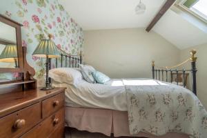 a bedroom with a bed with a dresser and a mirror at Lloft-Sarn in Sarn